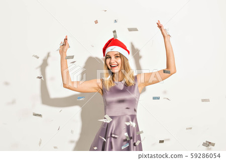 New year and holidays concept - Happy excited young woman in santa claus hat dancing and laughing New year and holidays concept - Happy excited young woman in santa claus hat dancing and laughing 59286054
