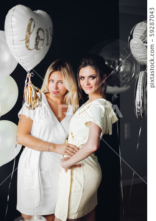 Beautiful bride posing with bridesmaid near Beautiful bride posing with bridesmaid near 59287043