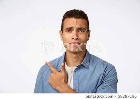 Skeptical, disappointed and doubtful handsome young man, frowning and grimacing from dislike Skeptical, disappointed and doubtful handsome young man, frowning and grimacing from dislike 59287186