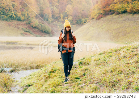 A woman walking with a backpack 59288748