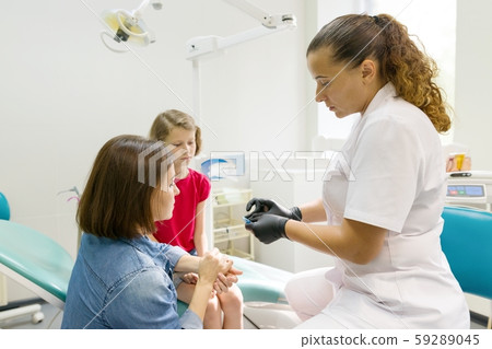 Orthodontist puts on, corrects the dental plate on the child Orthodontist puts on, corrects the dental plate on the child 59289045