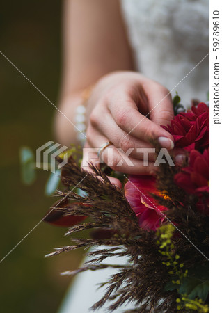 Bride holding bouquet with vinous flowers in 59289610