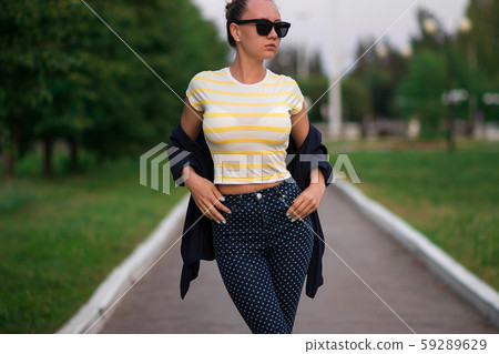 Confident fit young woman in sunglasses on walkway 59289629