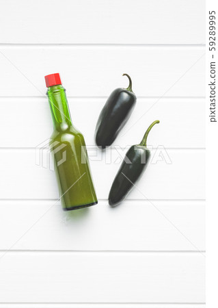 Green jalapeno peppers and tabasco sauce. Green jalapeno peppers and tabasco sauce. 59289995