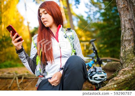 Photo of happy woman with cell phone in autumn forest 59290787