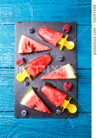 Photo of watermelon slices , fruit ice, blueberries on cutting board Photo of watermelon slices , fruit ice, blueberries on cutting board 59291086