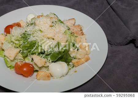 Caesar salad on a white plate and a dark Caesar salad on a white plate and a dark 59295068