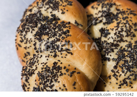 Buns with poppy seeds on a black plate and blue 59295142