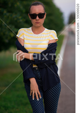Confident fit young woman in sunglasses on walkway 59300020