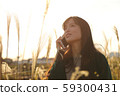 A woman who walks while listening to music in the field of Suki 59300431