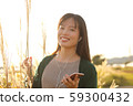 A woman who walks while listening to music in the field of Suki 59300432