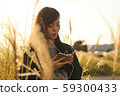 A woman who walks while listening to music in the field of Suki 59300433