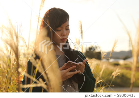 一個女人在Suki領域聽音樂時走路 一個女人在Suki領域聽音樂時走路 59300433