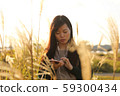 A woman who walks while listening to music in the field of Suki 59300434