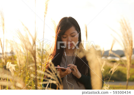 一個女人在Suki領域聽音樂時走路 59300434