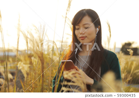 一個女人在Suki領域聽音樂時走路 一個女人在Suki領域聽音樂時走路 59300435