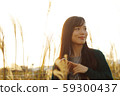 A woman who walks while listening to music in the field of Suki 59300437