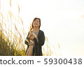 A woman who walks while listening to music in the field of Suki 59300438