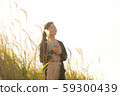 A woman who walks while listening to music in the field of Suki 59300439