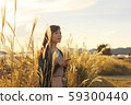 A woman who walks while listening to music in the field of Suki 59300440