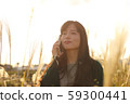 A woman who walks while listening to music in the field of Suki 59300441