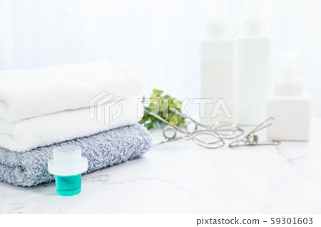 一條毛巾用洗滌劑洗淨並在房間裡折疊。家務勞動的形象。 一條毛巾用洗滌劑洗淨並在房間裡折疊。家務勞動的形象。 59301603