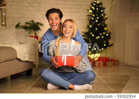 Christmas eve. Young man and woman with gift box Christmas eve. Young man and woman with gift box 59302954