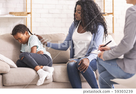 Mother soothing her upset disobedient little daughter at psychologist consultation Mother soothing her upset disobedient little daughter at psychologist consultation 59303239