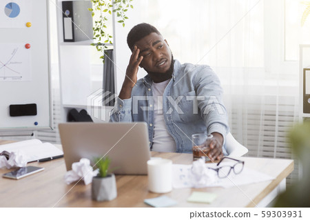 Stressed african american employee drinking alcohol in office 59303931