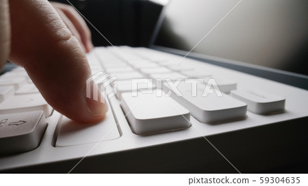 Close-up soft-focus finger typing on keyboard. Close-up soft-focus finger typing on keyboard. 59304635