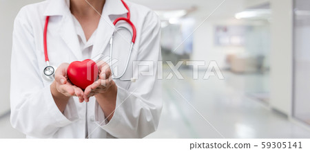 Doctor holding a red heart at hospital office. Doctor holding a red heart at hospital office. 59305141