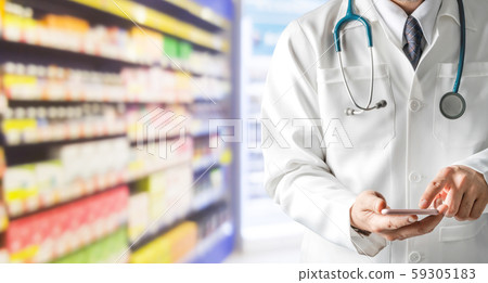 Male pharmacist using mobile phone at pharmacy. Male pharmacist using mobile phone at pharmacy. 59305183