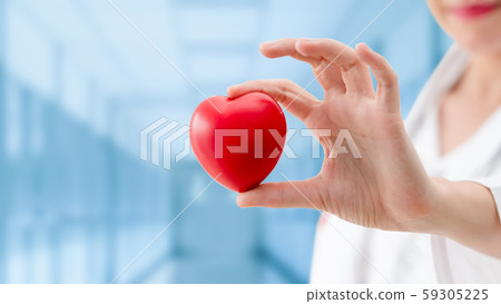 Doctor holding a red heart at hospital office. 59305225