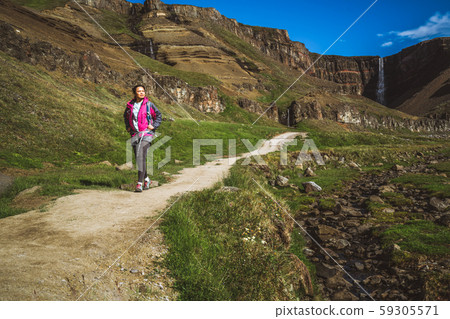 Traveler hiking at Hengifoss Waterfall, Iceland. Traveler hiking at Hengifoss Waterfall, Iceland. 59305571