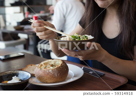 chiba, japan, 11/04/2019 , Woman eating a salad on a bowl with chopsticks. chiba, japan, 11/04/2019 , Woman eating a salad on a bowl with chopsticks. 59314918
