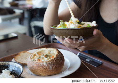 chiba, japan, 11/04/2019 , Woman eating  a salad on a bowl with chopsticks. 59314992