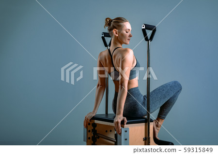 Palates trainer girl posing for a reformer in the gym. Fitness concept, special fitness equipment Palates trainer girl posing for a reformer in the gym. Fitness concept, special fitness equipment 59315849