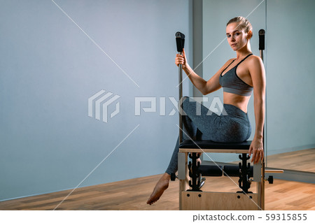 Palates trainer girl posing for a reformer in the gym. Fitness concept, special fitness equipment Palates trainer girl posing for a reformer in the gym. Fitness concept, special fitness equipment 59315855