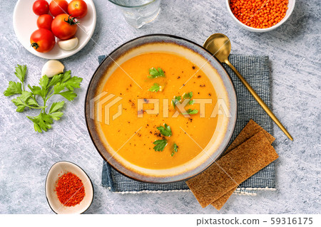 Winter spicy lentil cream soup on light blue 59316175