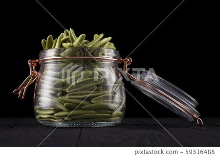 Jar of foglie spinach pasta on wooden table isolated on black background Jar of foglie spinach pasta on wooden table isolated on black background 59316488
