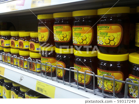 Processed honey packed in the plastic bottle and displayed on the shelf to the customer in the supermarket.   59317249