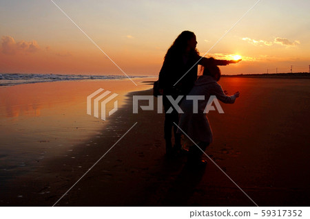 一個捉住陽光的女人和一個試圖撿起陽光以免掉落的女人 59317352