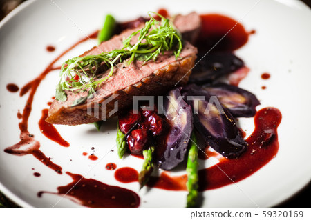 Duck breast served on a plate in restaurant 59320169