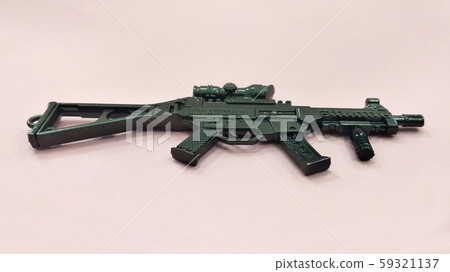 Selected focused on steel model of military gun in miniature scale isolated on red background. Sale as a collector item for military gear collector and hobbyist.  59321137