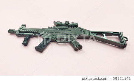 Selected focused on steel model of military gun in miniature scale isolated on red background. Sale as a collector item for military gear collector and hobbyist.  59321141