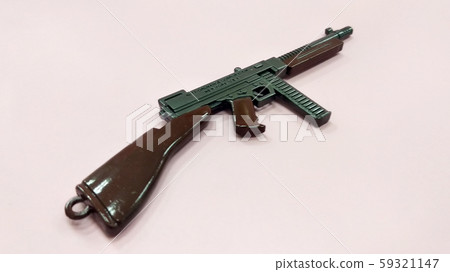 Selected focused on steel model of military gun in miniature scale isolated on red background. Sale as a collector item for military gear collector and hobbyist.  59321147