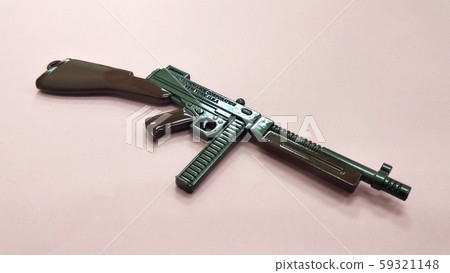 Selected focused on steel model of military gun in miniature scale isolated on red background. Sale as a collector item for military gear collector and hobbyist.  59321148