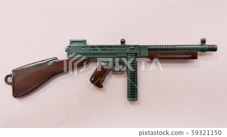 Selected focused on steel model of military gun in miniature scale isolated on red background. Sale as a collector item for military gear collector and hobbyist.  59321150