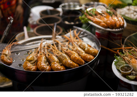 Fried king shrimps seafood by fire and BBQ Flames. Restaurant Barbecue at the night market. 59321282