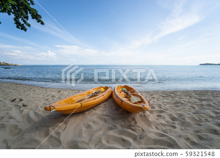 Two colorful orange kayaks on a sandy beach ready for paddlers in sunny day. Several orange 59321548